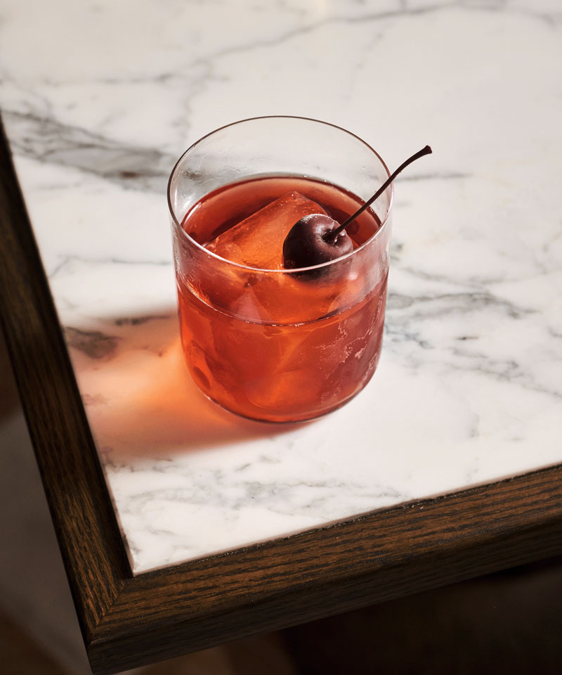 Cherry negroni. A pink drink topped with a cherry.
